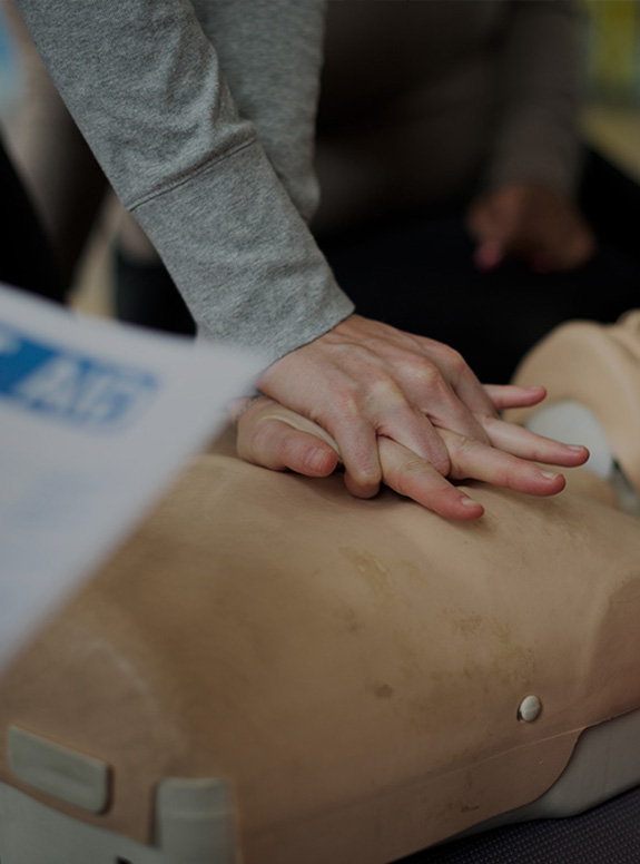 Cours d'un homme avec un massage cardiaque sur un mannequin de secours