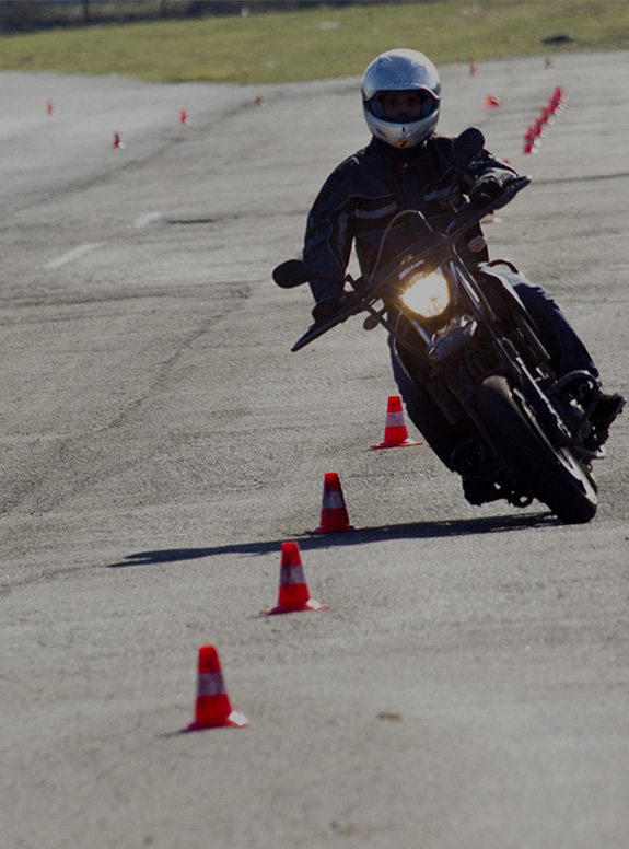 Un homme slalom entre des plots avec une moto