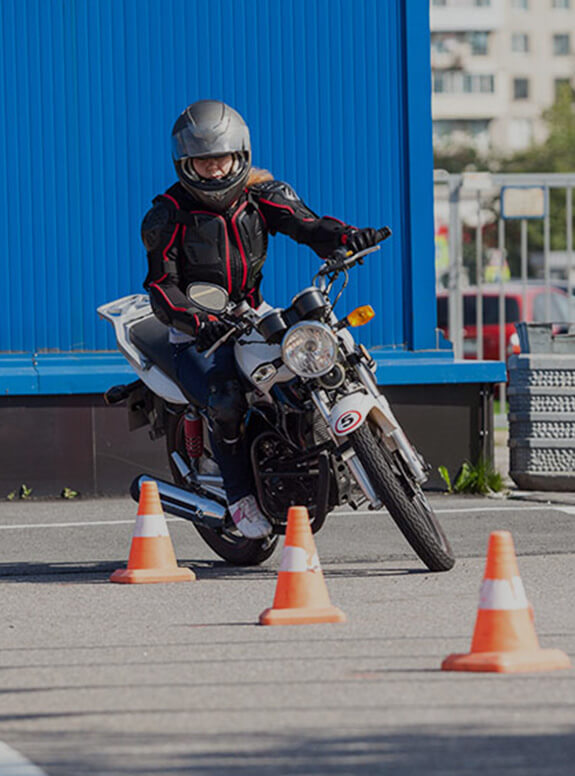 Une femme slalom entre des plots avec une moto