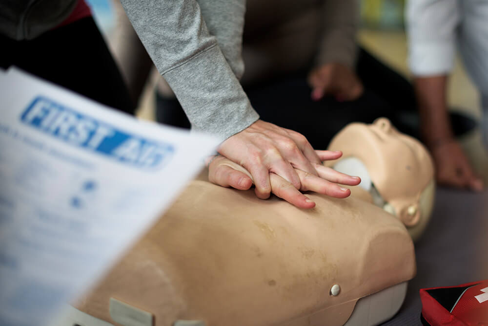 Cours d'un homme avec un massage cardiaque sur un mannequin de secours